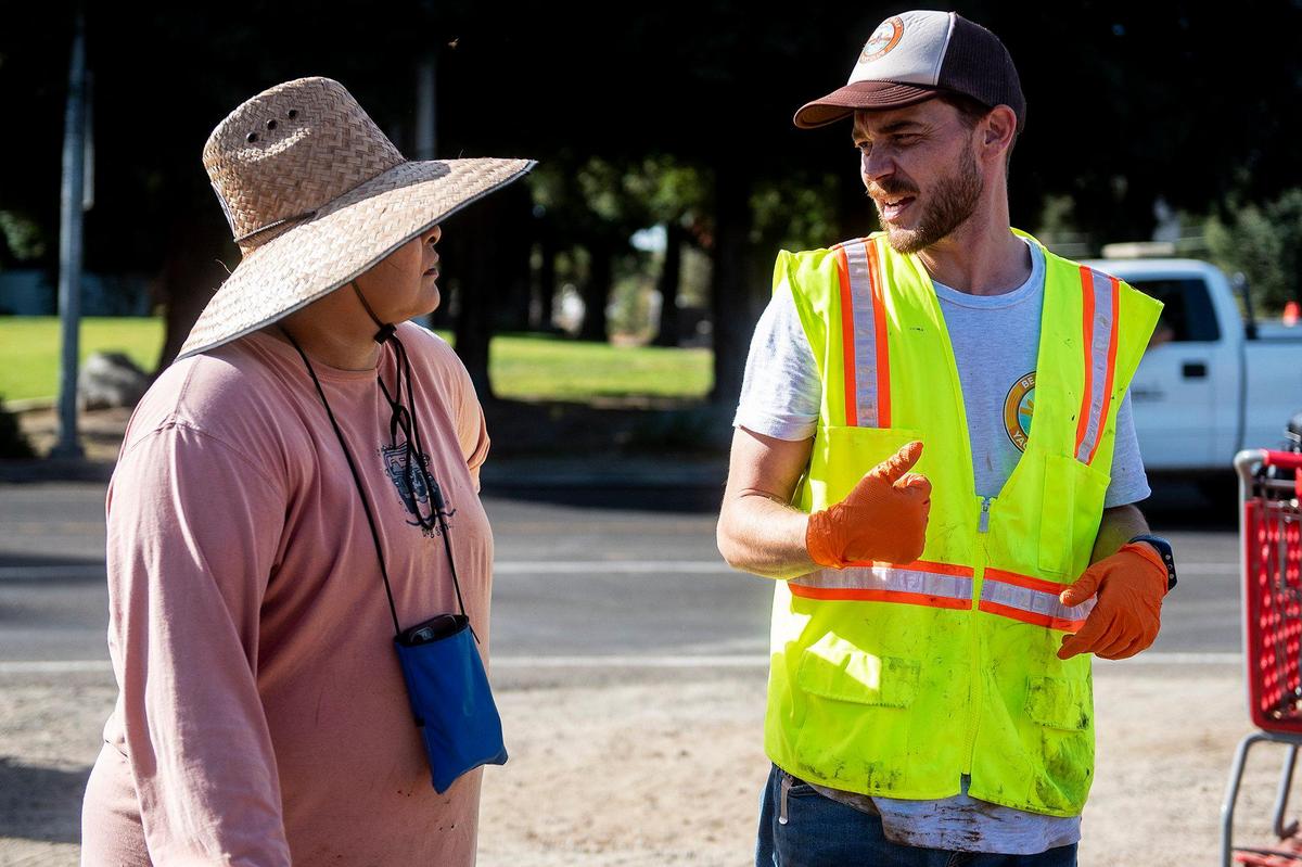 Co-founder and president of Merced non-profit Bear Creek Yacht Club, Zachary Wells, 35, right, speaks with volunteer Diana Thompson, 59, of Merced, left, during a cleanup event along the banks of Bear Creek near McKee Road in Merced, Calif., on Saturday, Oct. 14, 2023.