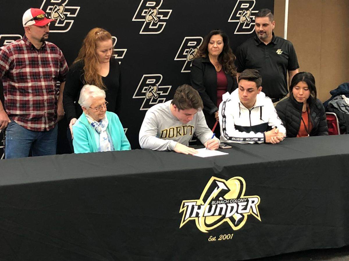 Surrounded by his family, Buhach Colony’s Owen Thomas signs his national letter of intent to accept a football scholarship to Dordt College in Iowa.