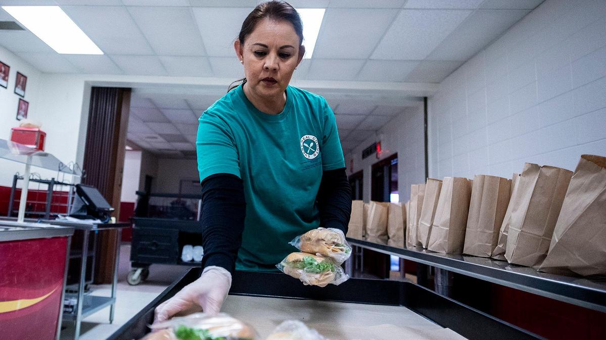 Mayra Perez, assistant cafeteria supervisor at Golden Valley High School, prepares meals to be handed out during the first day of closure at Golden Valley High School in Merced, Calif., on Thursday, March 19, 2020. All Merced County schools closed Thursday in response to the coronavirus.