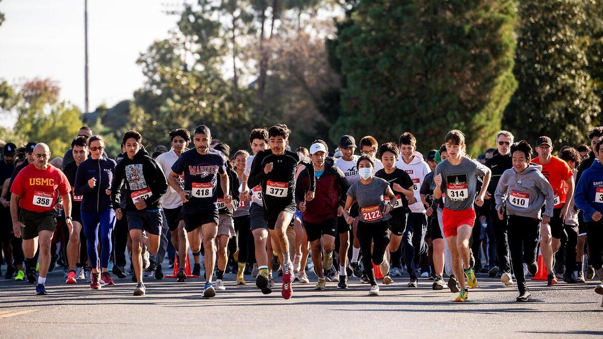 Runners and walkers take off from the start line during the annual Run for the Fallen 5K/10K on the Merced College campus in Merced, Calif., on Sunday, Nov. 7, 2021.