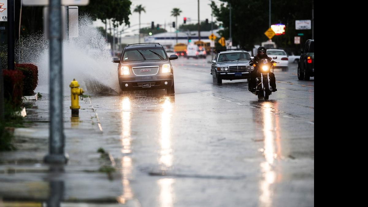
A sport utility vehicle drives through standing water in the flooded right lane of Martin Luther King Jr. Way during a heavy rainstorm in Merced on Thursday.
