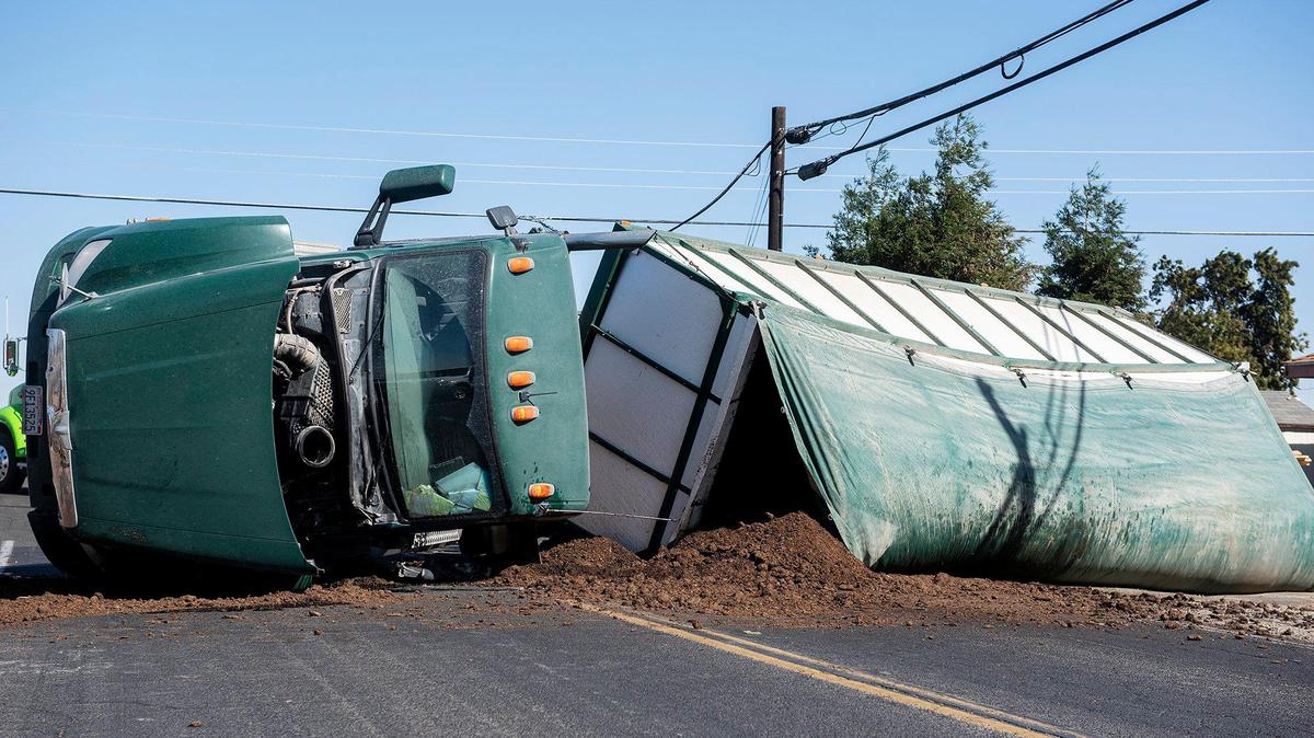 The California Highway Patrol responds to the scene of a collision involving an overturned big rig hauling about 80,000 pounds of manure at the intersection of Highway 140 and Thornton road in Merced County, Calif., on Tuesday, Oct. 12, 2021.