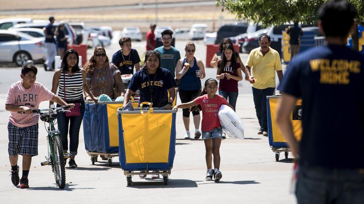 University of California, Merced students push bins full of belongings during move in day for on-campus residents at UC Merced in Merced, Calif., on Saturday, Aug. 19, 2017.