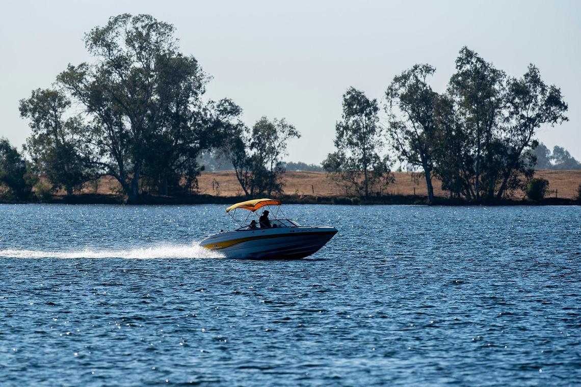A boat skips across the surface of the water at Lake Yosemite in Merced, Calif., on Tuesday, Aug. 30, 2022.
