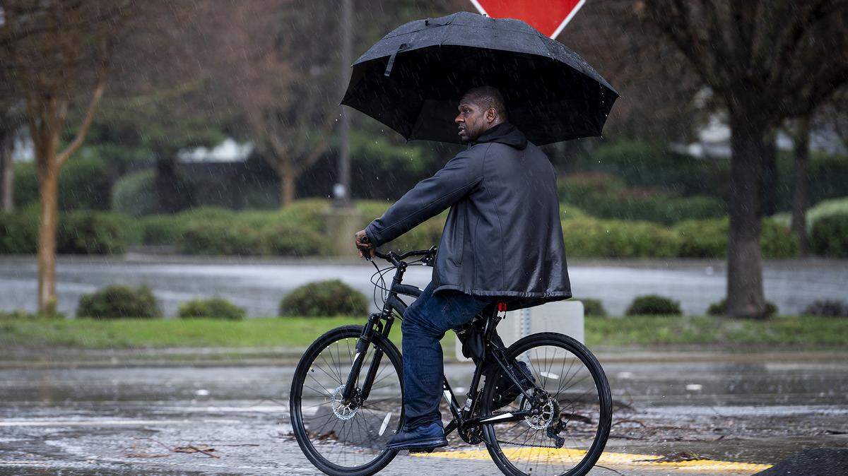 A bicyclist crosses M Street at Buena Vista Drive during a short rain and hail storm in Merced, Calif., on Monday, Jan. 16, 2023.