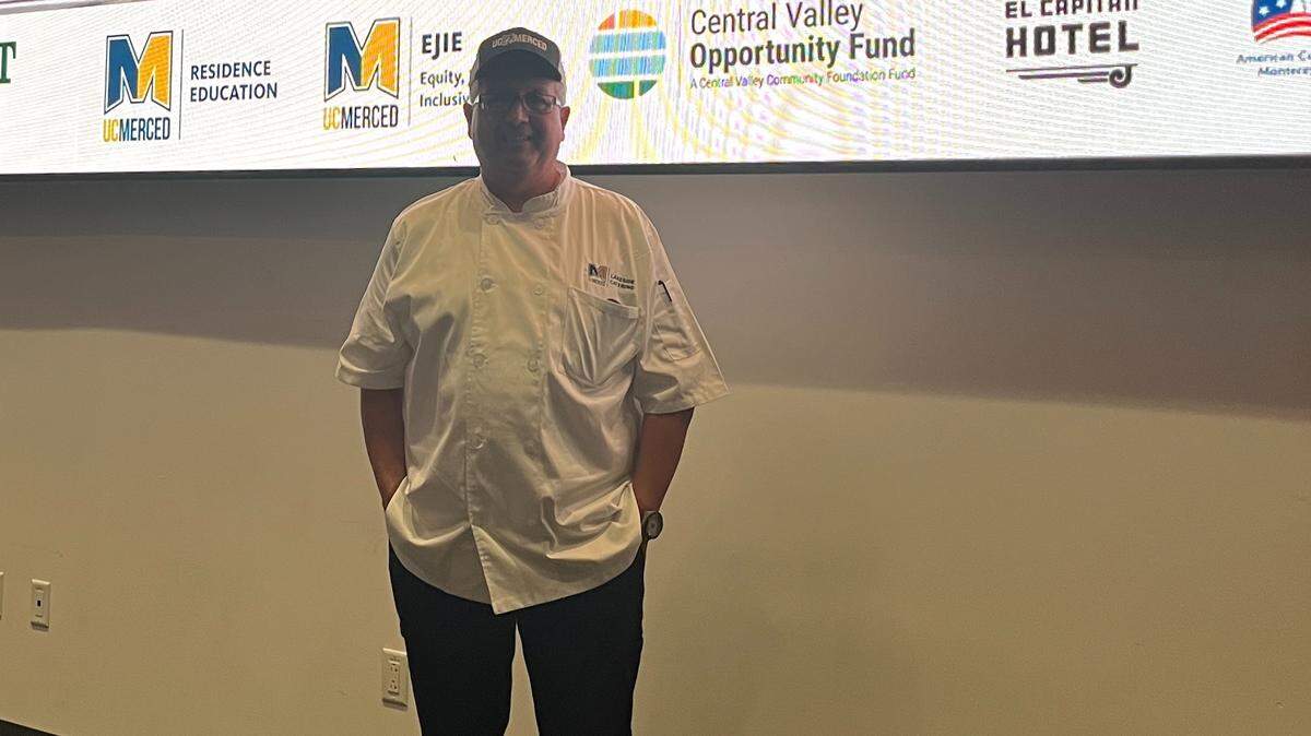 Chef Mitch Vanagten standing in front of a projected banner for “The Sioux Chef.”