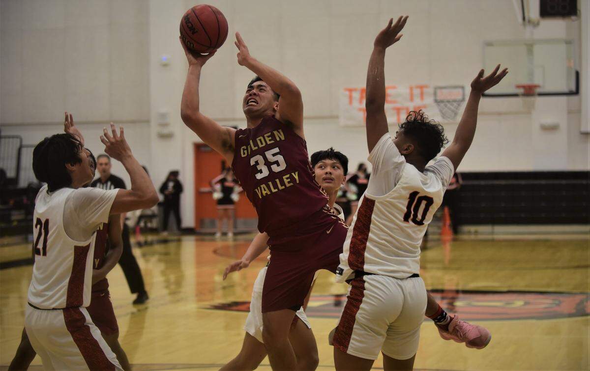 Golden Valley senior Mateo Tangaan (35) goes up for a shot as Merced’s Jaylen Thao-Booth (10) and Israel Henley-amey (21) defend during a game on Friday, Jan. 21, 2022 at Merced High School in Merced, Calif.