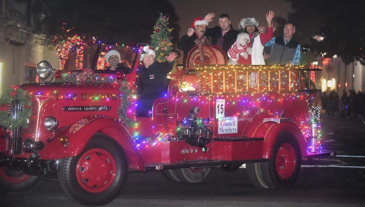 Los Banos Fire Chief Mason Hurley (front) drives a fire engine filled with the Los Banos City Council members during the Annual Los Banos Christmas Parade on Friday, Dec. 3, 2021 in Los Banos, Calif.