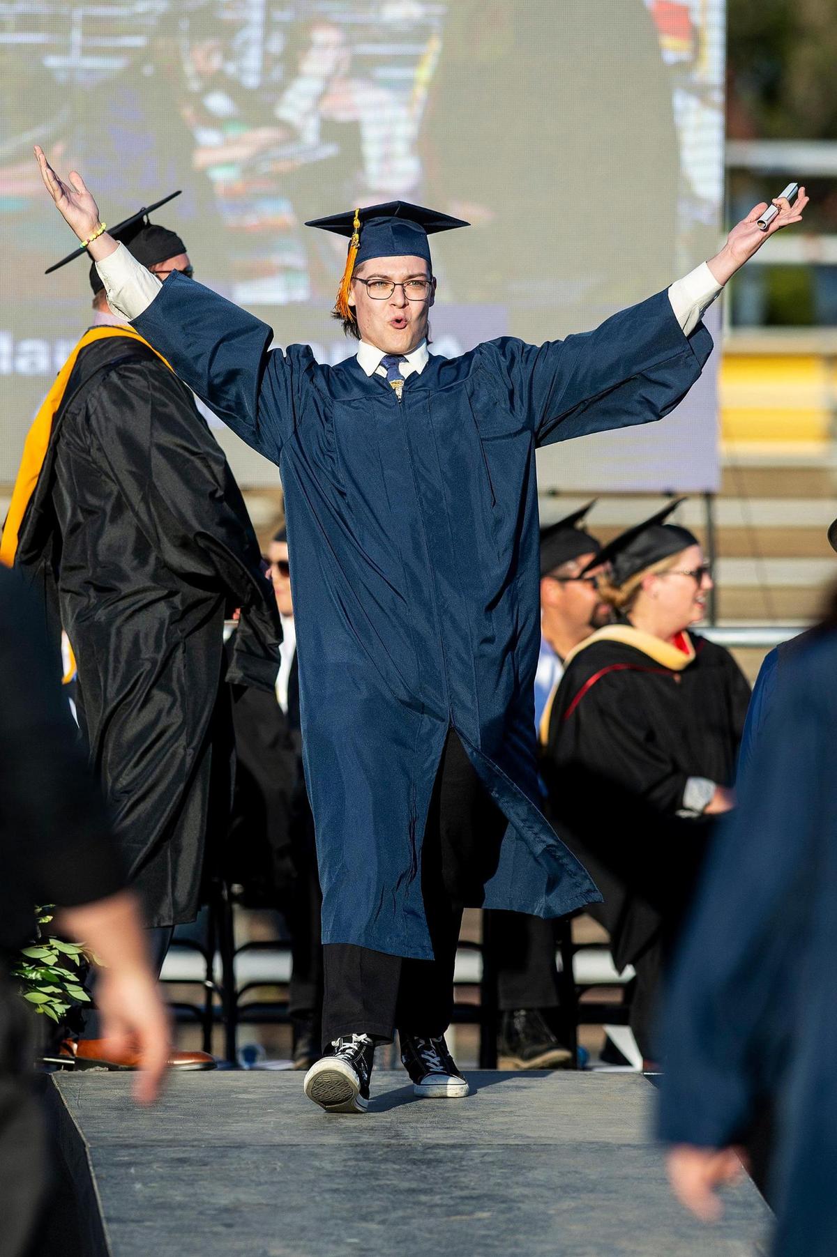 Graduates celebrate while crossing the stage during a commencement ceremony for the Merced College class of 2022 on the Don Odishoo Field at Stadium ’76 in Merced, Calif., on Friday, May 20, 2022.