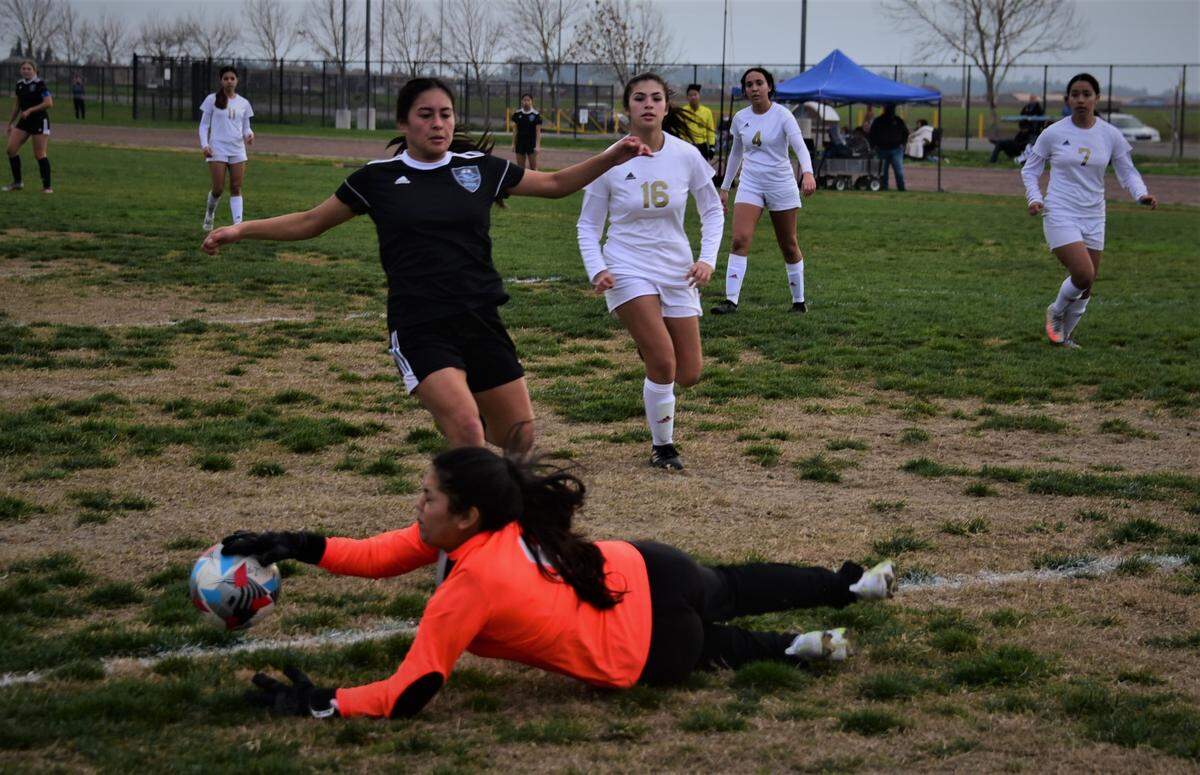 Golden Valley goalie Vikki Valenzuela dives to gather the ball as an El Capitan player races for the ball during a match on Friday, January 7, 2022 at El Capitan High School in Merced, Calif.