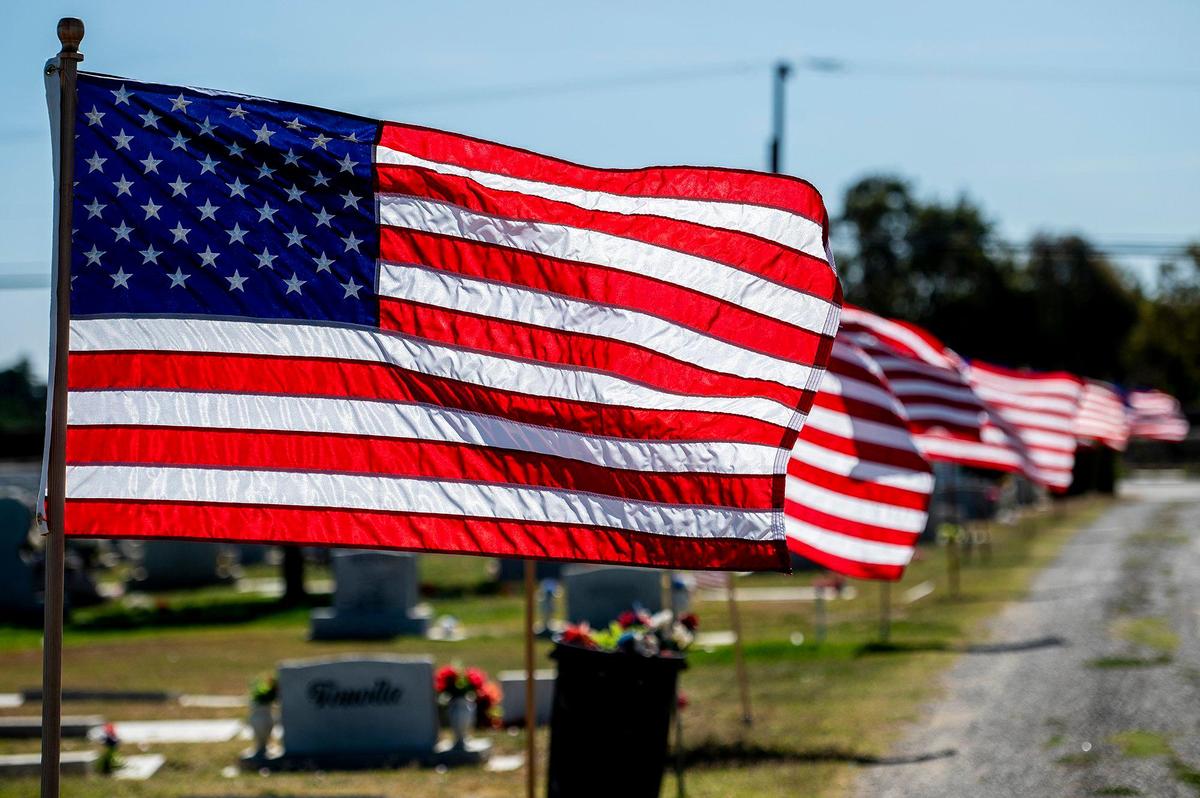 American flags line the road into the Los Banos Cemetery during a Memorial Day ceremony in Los Banos, Calif., on Monday, May 30, 2022.