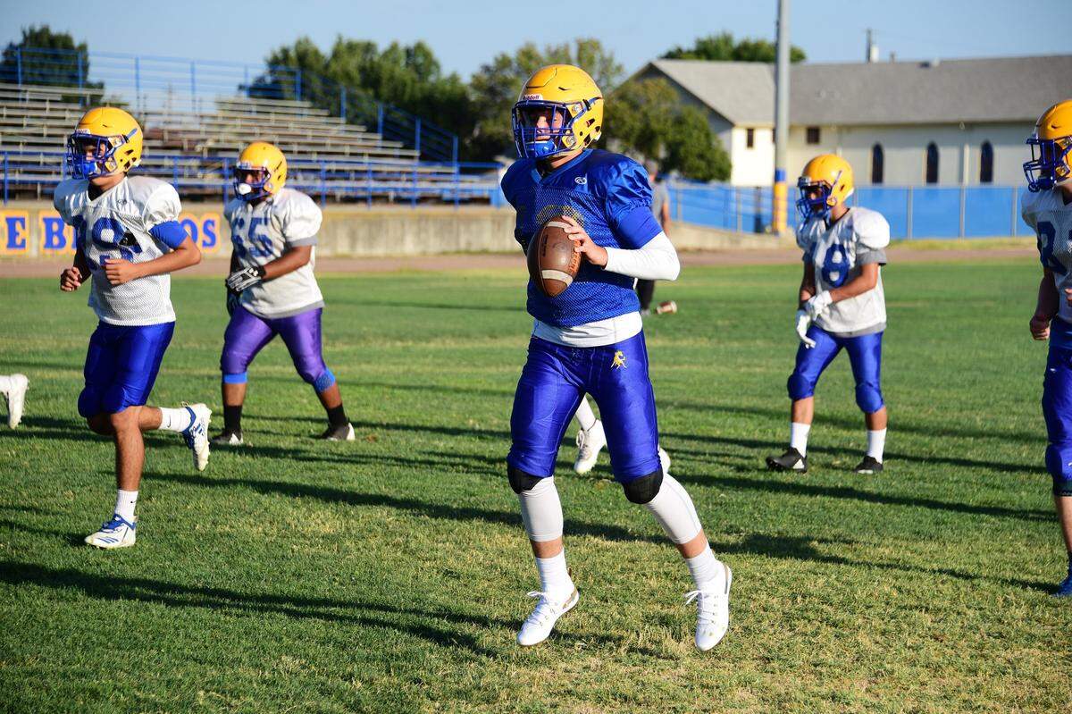 Sophomore quarterback Trent Calvert goes through warm-ups during a Dos Palos High football practice on Wednesday, Aug. 7, 2019 at Dos Palos High School.