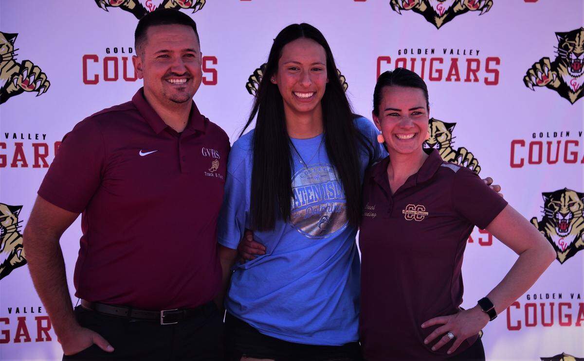 Golden Valley High senior Jazmine Severo (center) poses for a photo with Golden Valley track and field coaches John and Jacqueline Wooding after Severo signed her national letter of intent to accept a scholarship to the College of Staten Island in New York on Thursday, March 22, 2022 at Golden Valley High School in Merced, Calif.