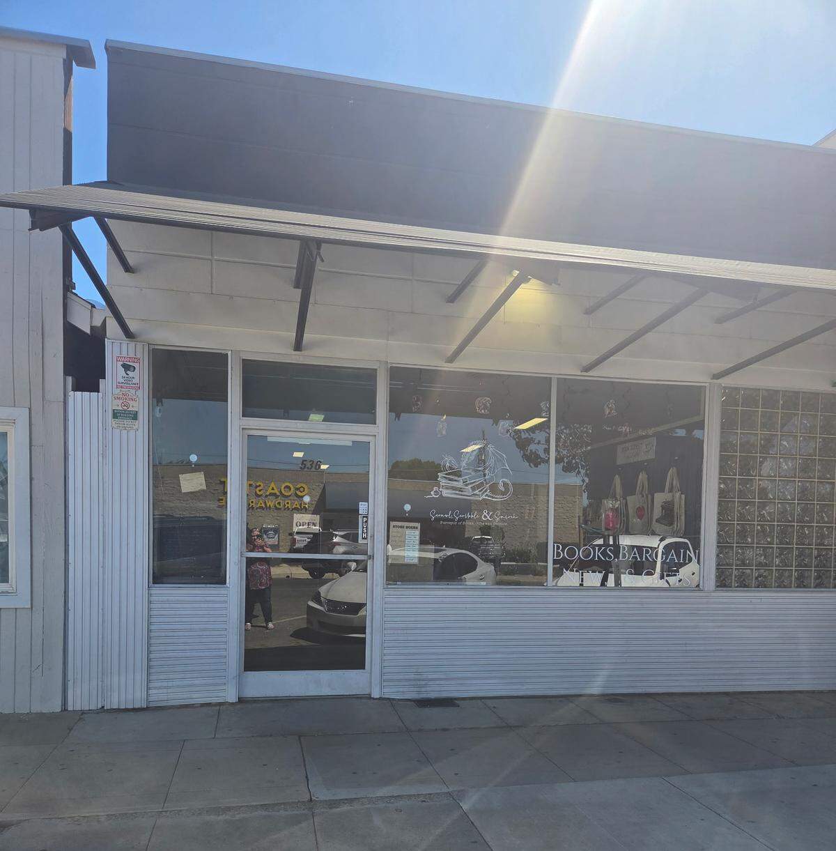 The outside of a bookstore painted white with large glass windows.