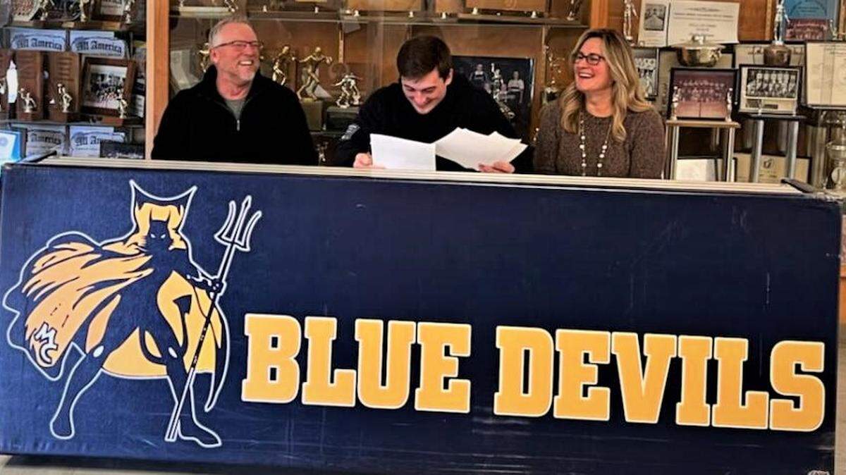 Merced College sophomore quarterback Ryan Kraft signs his national letter of intent to accept a scholarship to Wagner College in Staten Island, New York as his parents Tom and Sandra look on during a ceremony at Merced College on Wednesday, Dec. 15, 2021.