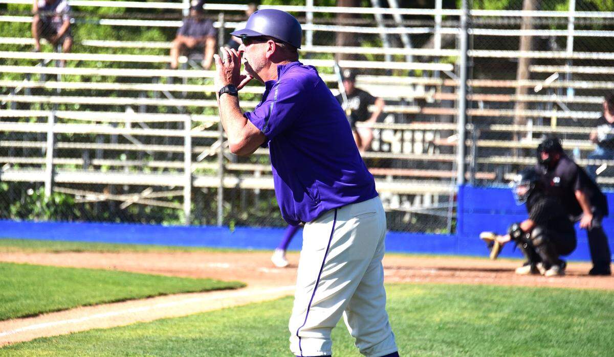 El entrenador de beisbol de Livingston High, Matt Winton, grita instrucciones a un corredor de base mientras entrena la tercera base durante un partido contra los Enochs, el martes 2 de abril de 2024, en el Memorial Ballpark de Atwater.