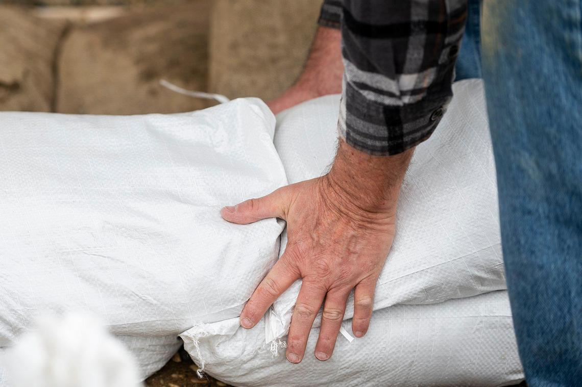 Chief Operating Officer of Leap Carpenter Kemps Insurance, Dave Cribb, 64, of Oakdale, places sandbags along the front of the home of one of the company’s employees on Driftwood Drive, while preparing for upcoming rainstorms in Merced, Calif., on Thursday, March 9, 2023. According to the resident, the home took on about five inches of water during the previous heavy rains and flooding.