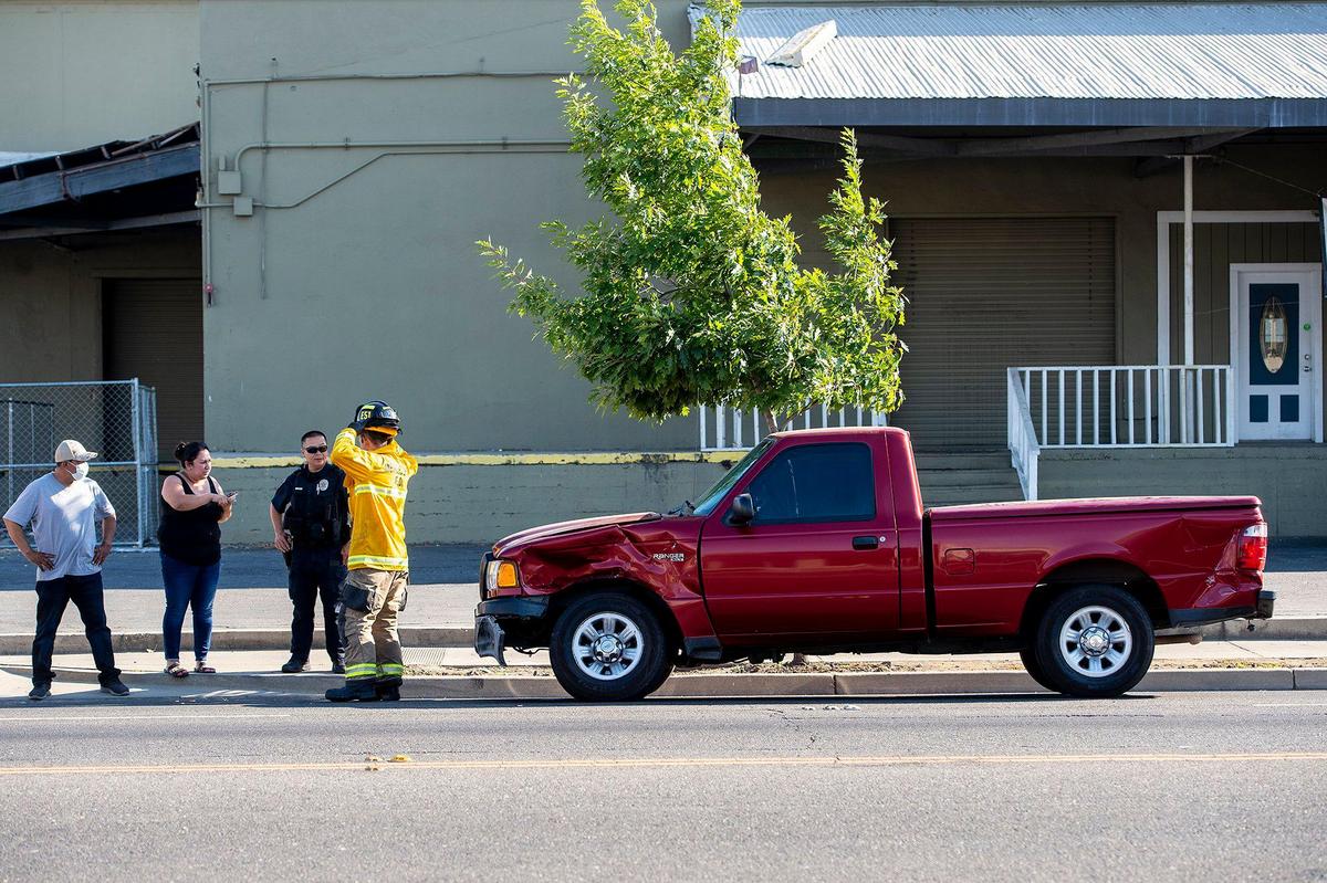 A Ford Ranger sits on West 16th Street as Merced Police, Merced City Fire Department and Riggs Ambulance Service respond to the scene of a hit-and-run collision near the intersection of Martin Luther King Jr. Way and West 16th Street in Merced, Calif., on Sunday, July 19, 2020. Authorities said the driver of a Toyota Camry involved in the collision left before officers arrived. The driver of the Ford was transported to an area hospital for treatment of injuries, police said. According to authorities, the crash is under investigation.