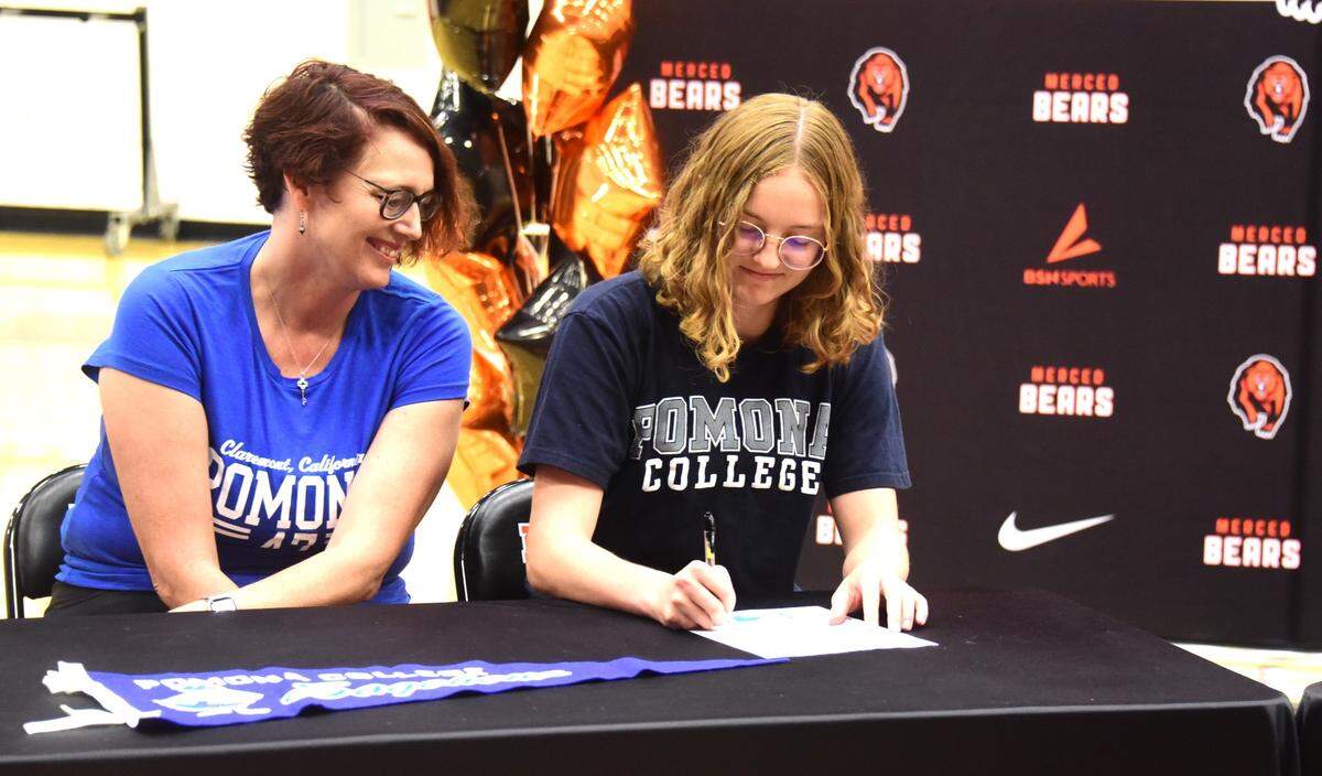 Merced High School senior Elsa Van Dyke (right) signs her national letter of intent to compete in track at Pomona College while her mother Irenee Beattie looks on during a ceremony at the high school on Tuesday, May 28, 2024.
