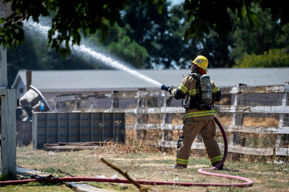 Cal Fire Merced County firefighters and City of Merced firefighters battle a structure fire which damaged two homes in the 1800 block of Dunn Road in Merced County, Calif., on Wednesday, Aug. 23, 2023. Fire officials said the cause of the fire is under investigation.