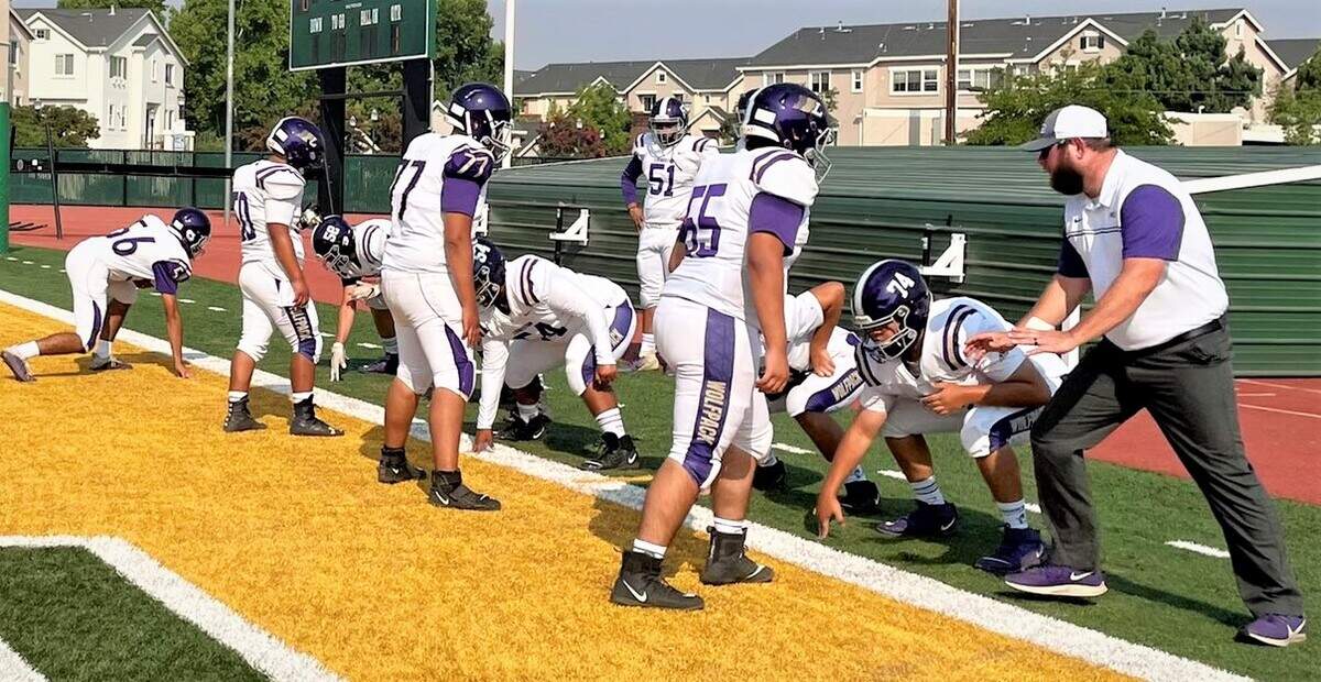 Livingston assistant coach Brian Wine goes through offensive line drills before a game at Livermore earlier this season.