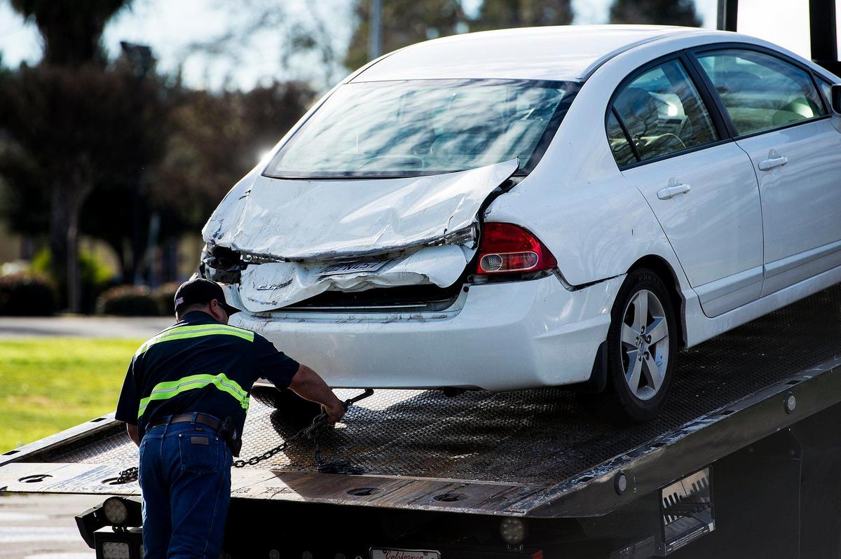 A vehicle that was struck by a falling tree is loaded onto a flatbed at Merced High School in Merced, Calif., on Thursday, Feb. 14, 2019. According to administrators, the tree fell around 2:15 p.m. and struck one car that was occupied by two Merced High School Student. That students did not sustain any injuries.