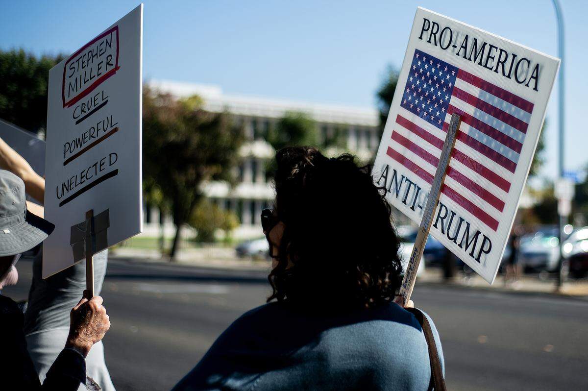 Protesters carry signs while lining M Street during a “No Kings” protest in Merced, Calif., on Saturday, Oct. 18, 2025. 
