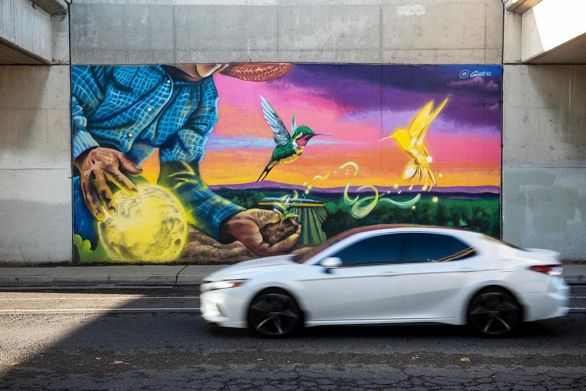 A vehicle drives past a mural on a wall of the Highway 99 M Street overpass in Merced, Calif, on Thursday, Dec. 12, 2024.