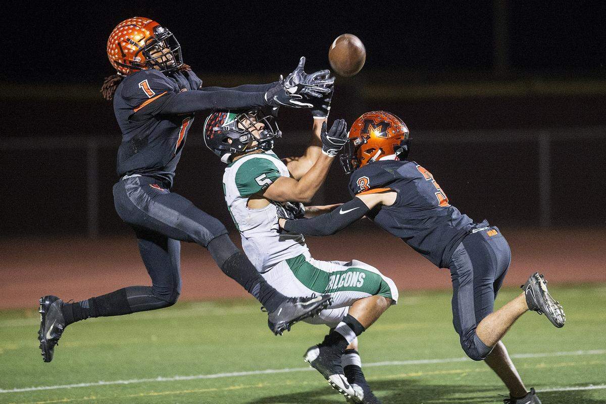 Merced seniors Dhameer Warren (1) and Ronnie Miranda III (3) break up a pass intended for River Valley senior Evan Strickland (5) during a CIF Sac-Joaquin Section Division III playoff game at Veterans Stadium in Merced, Calif., on Friday, Nov. 9, 2018. The Falcons beat the Bears 45-40.