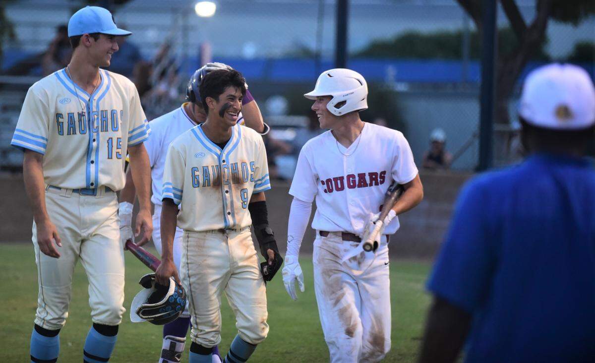 El Capitan High School’s Braylen Centeno, center, and Golden Valley’s Koen Heupel, right, react after they both score runs for the Merced County All-Stars during the County Clash All-Star Game at Merced College on Saturday, June 17, 2023.