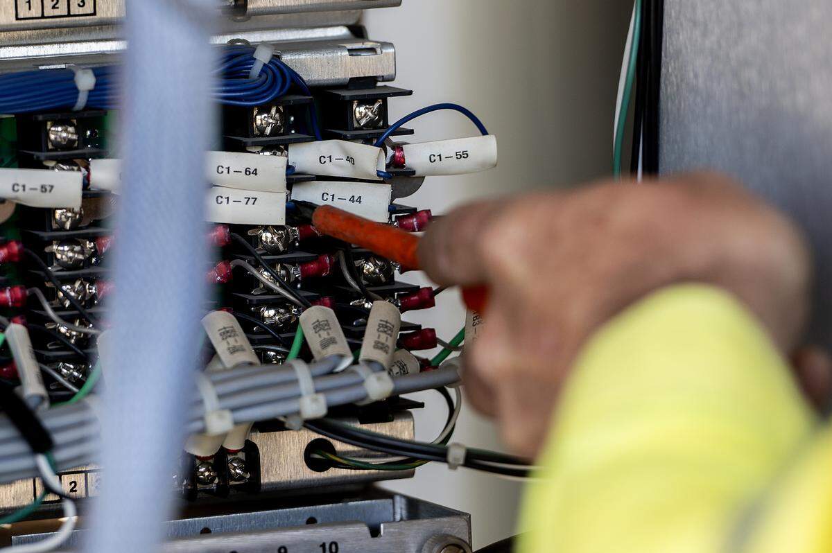 Tanner Harkreader, 28, a lead lighting technician with the City of Merced, performs routine maintenance on a traffic signal cabinet at the intersection of Olive and Parsons avenues in Merced, Calif., on Thursday, July 31, 2025. 