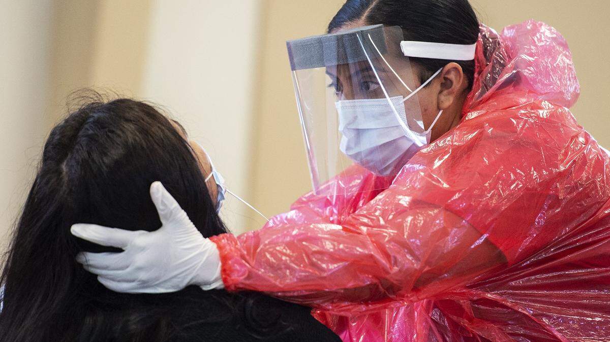 Ivana Barajas, a phlebotomist with Integrity Health, collects a sample from a patient at a COVID-19 testing site located at the Merced County Fairgrounds in Merced, Calif., on Monday, May 4, 2020.