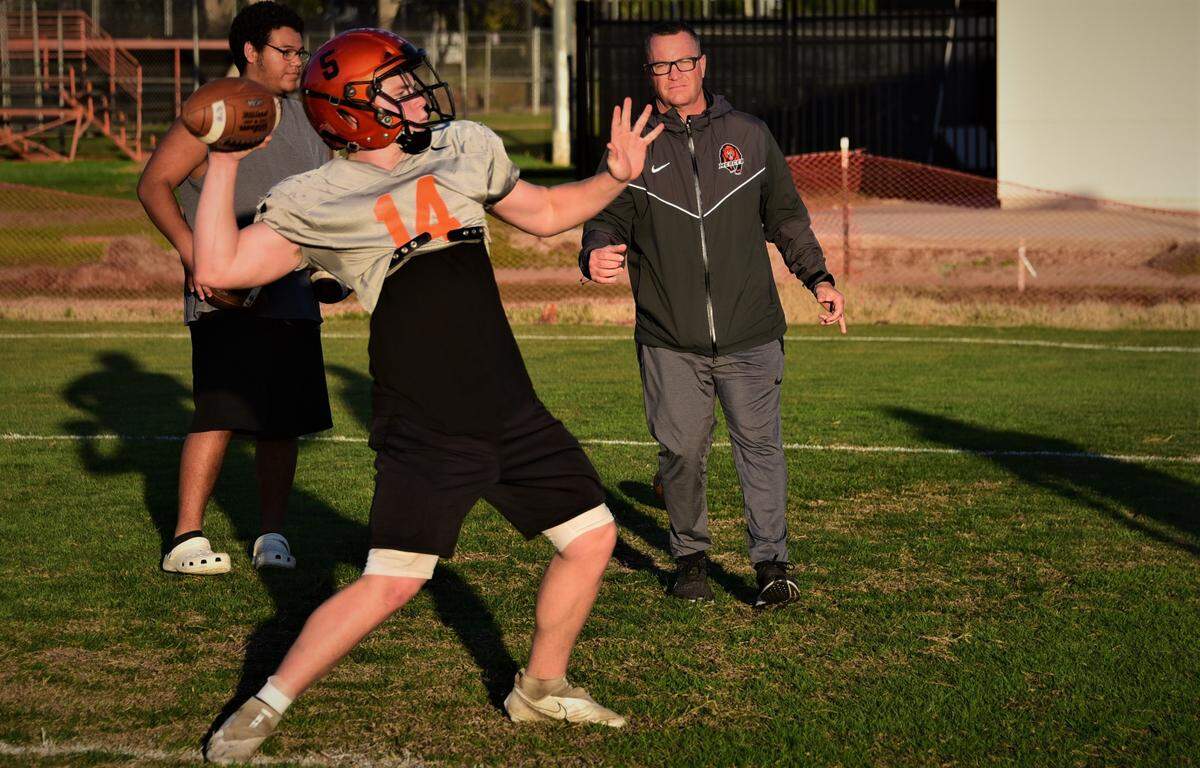 Merced High senior quarterback Seth Scheidt while his father/head coach Rob Scheidt looks on in practice on Tuesday, Nov. 23, 2021 at Merced High School.