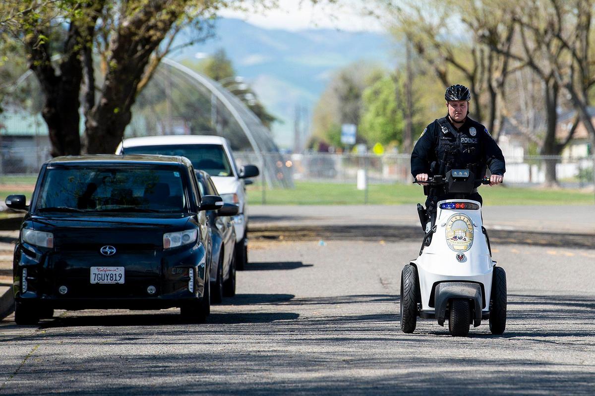 Gustine Police Officer Corey Bayer drives a three-wheel electric vehicle along South Avenue to pick up an order for delivery from Wolfsen’s Meat and Sausage in Gustine, Calif., on Monday, March 23, 2020. The City of Gustine is offering free delivery of food and prescriptions to residents living within city limits as a way to aid the residents during the coronavirus pandemic.