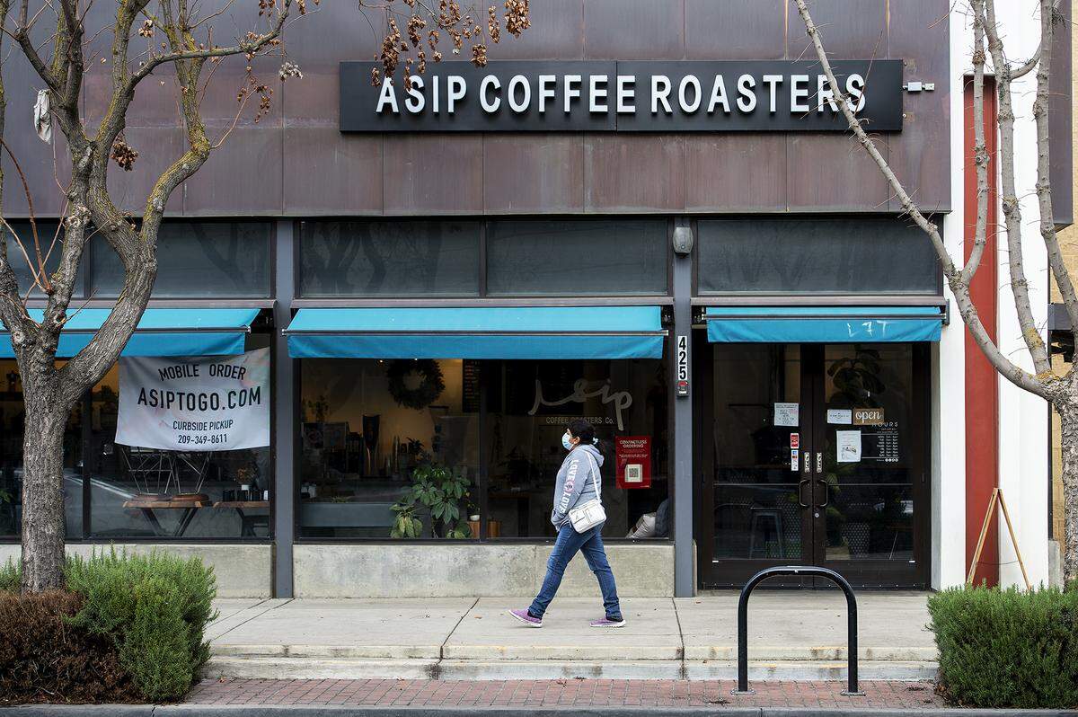 A pedestrian walks past Asip Coffee Roasters located at 425 W. Main Street in Merced, Calif., on Monday, Jan. 25, 2021. 