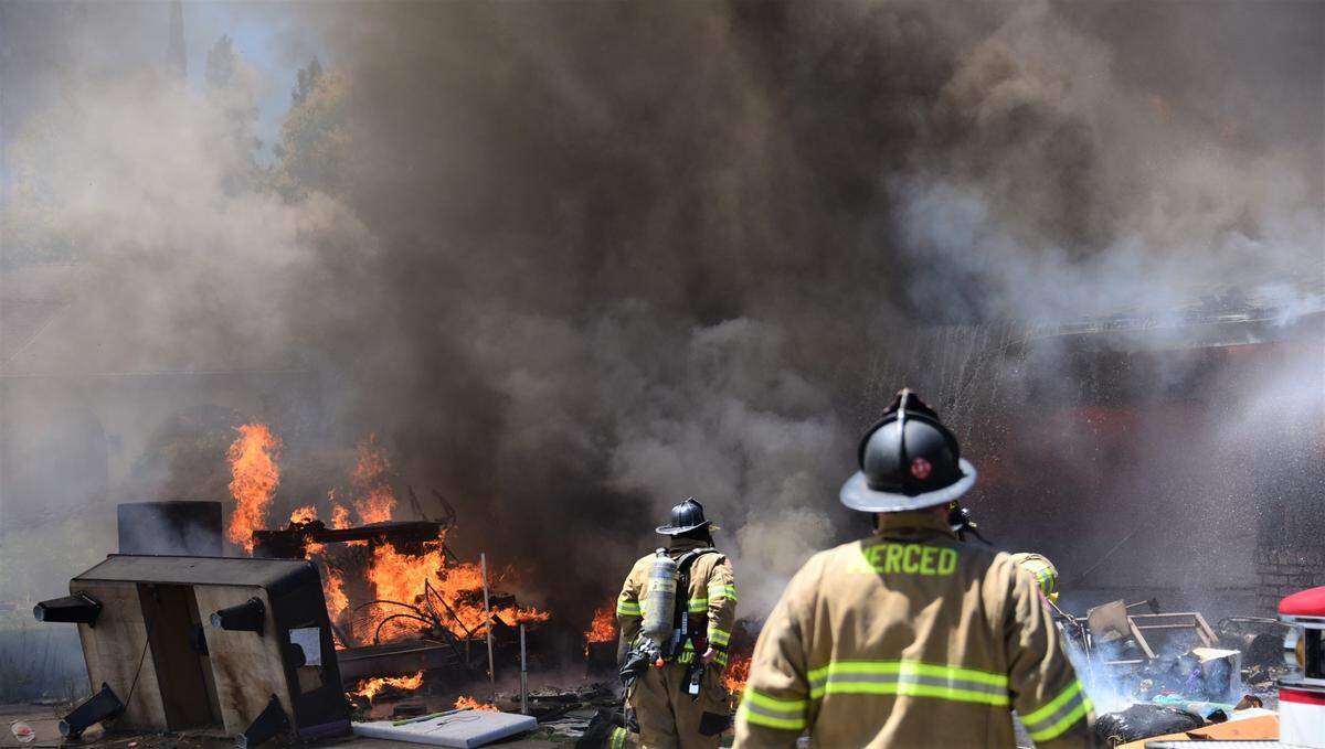 Merced Fire Department crews battle a blaze that damaged two homes on De Anza Court in Merced on Friday, July 28, 2023.