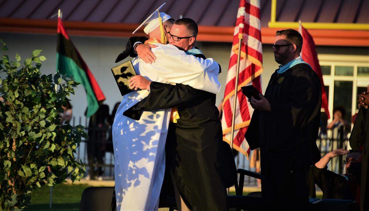 Merced High School senior Seth Scheidt hugs his father Rob Scheidt, who is the Merced football coach, during the Merced High School graduation ceremony on Thursday, June 2, 2022.