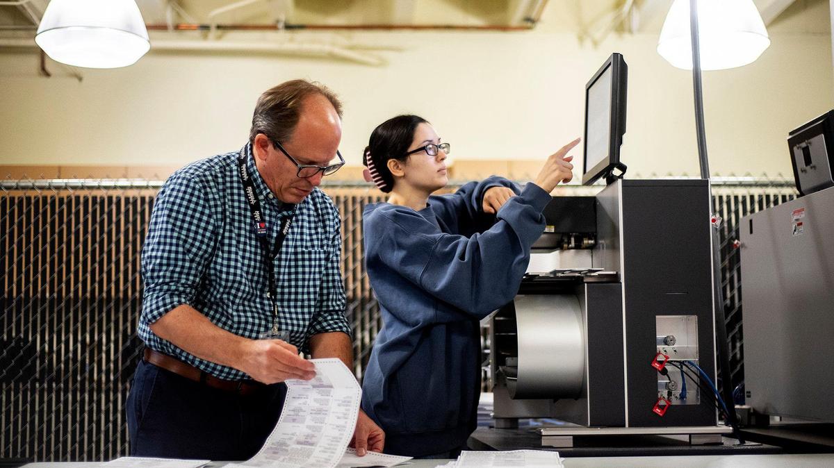 Election specialist Jason Fragulia, 54, of Merced, left, and extra help election worker Lily Valencia, 35, of Livingston, right, work to feeds ballots into a tabulator machine at the Merced County Election Warehouse in Merced, Calif., on Thursday, Nov. 7, 2024. Election officials and workers continue to count tens of thousands of ballots following the Nov. 5, General Election.