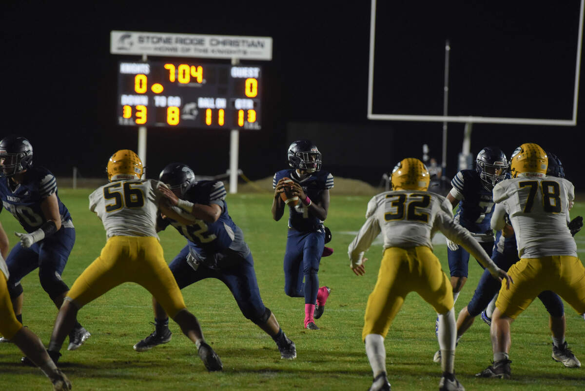 Stone Ridge Christian quarterback Marcus Gray looks for a receiver as Mariposa County defenders close in during the first quarter of Friday night’s game in Franklin.
