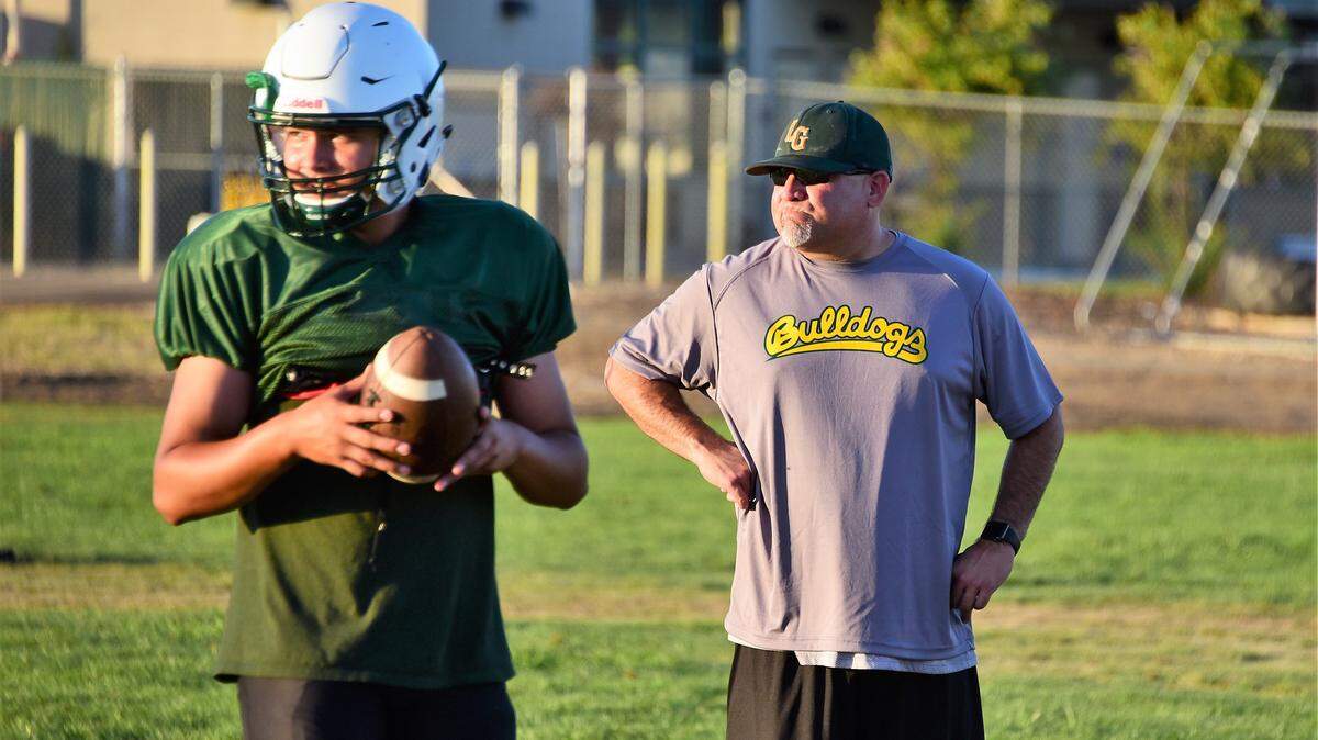 Sophomore Aaron Martinez practices as his father Le Grand football coach Aaron Martinez looks on.
