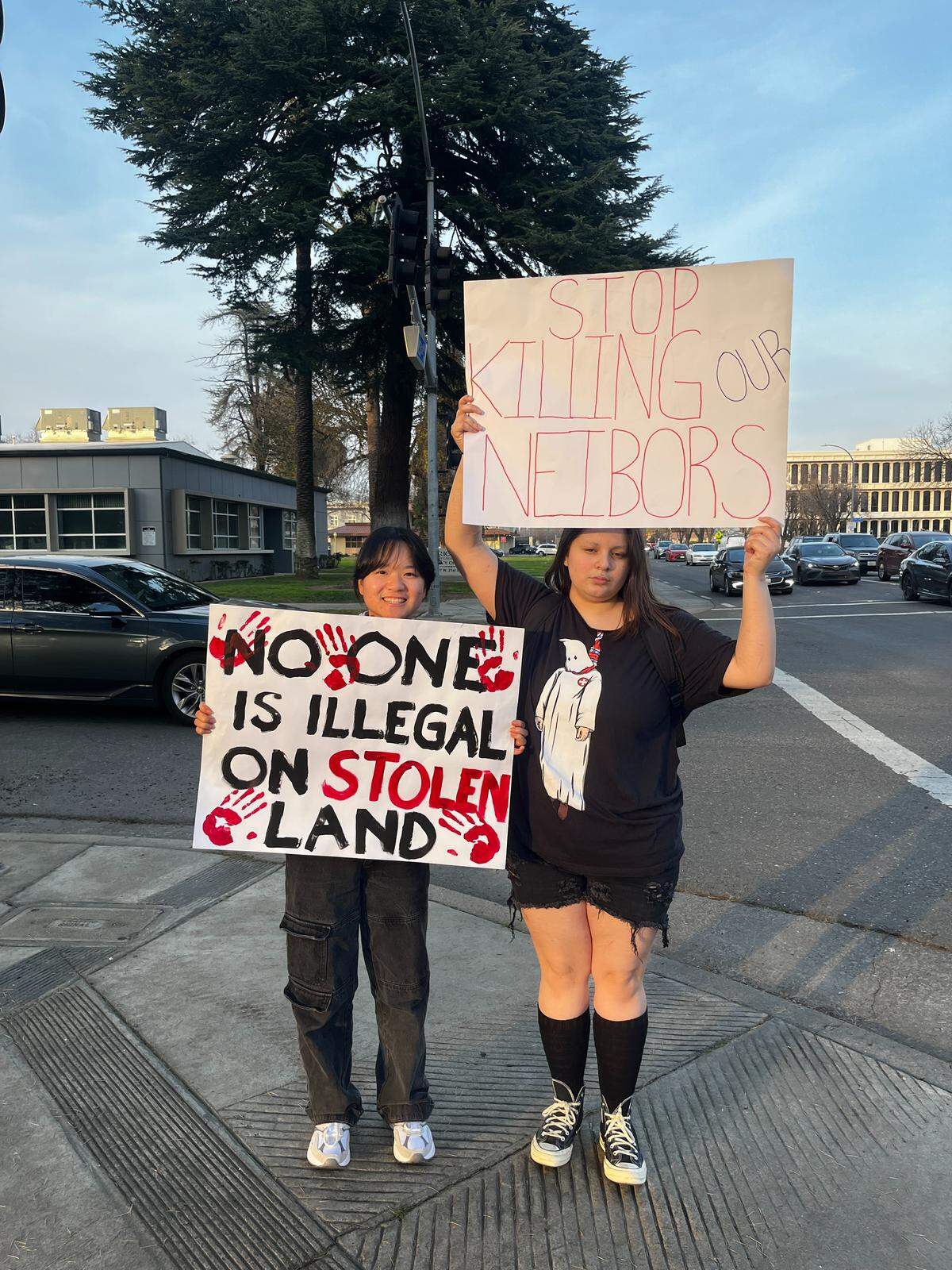 Merced College students Autumn Xiong and Max Coronado hold signs at the protest.