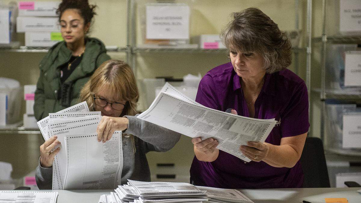 Renee Smyth, 55, of Atwater, left, and Kathy Souza, 60, of El Nido, right, count ballots at the Merced County Elections Warehouse in Merced, Calif., on Tuesday, Nov. 5, 2024.