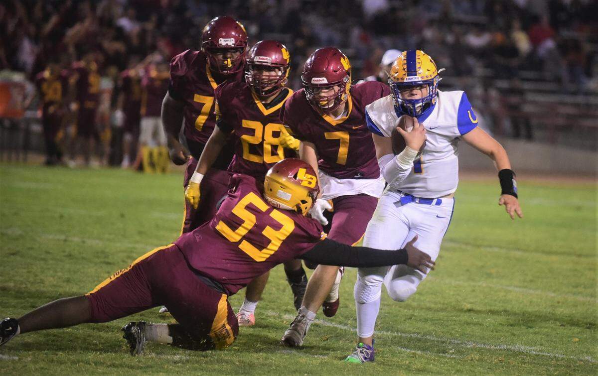 Dos Palos quarterback Trent Calvert runs up field against Los Banos in the Westside War on Friday, Aug. 20, 2021.