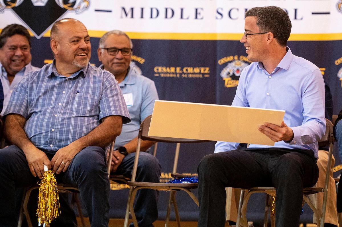 United Way of Merced County Interim CEO Robert Hypes, right, looks to Merced County District 1 Supervisor Rodrigo Espinosa, left, after Hypes was presented with a donation of $75,000 to the United Way of Merced County by Comcast, during a ceremony held by the company announcing a $4.5 million investment to bring high-speed internet and broadband services to the area, at Cesar E. Chavez Middle School in Planada, Calif., on Monday, April 17, 2023. According to Nathan Ahle, Comcast Director of Government Affairs for the South Valley, the $4.5 million investment involves extending the existing network from nearby Merced into the town of Planada.