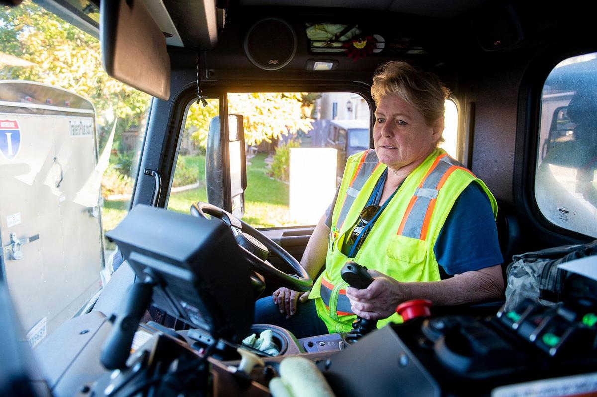 Merced Refuse Equipment Operator Kristie Light, 56, drives her route collecting refuse in Merced Calif. on Thursday, Oct. 24, 2024. According to Light who previously drove commercial trucks across parts of the country and would routinely be gone for 70-80 hours a week, her current job with the city allows her to spend more time at home. “It’s nice to go to work and like your job,” said Light.