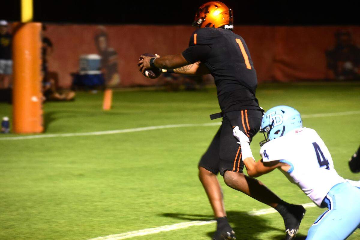 Merced High quarterback Quintell Dupree (1) reaches out for a touchdown after a 30-yard run during a game against Downey on Friday, Sept. 6, 2024.