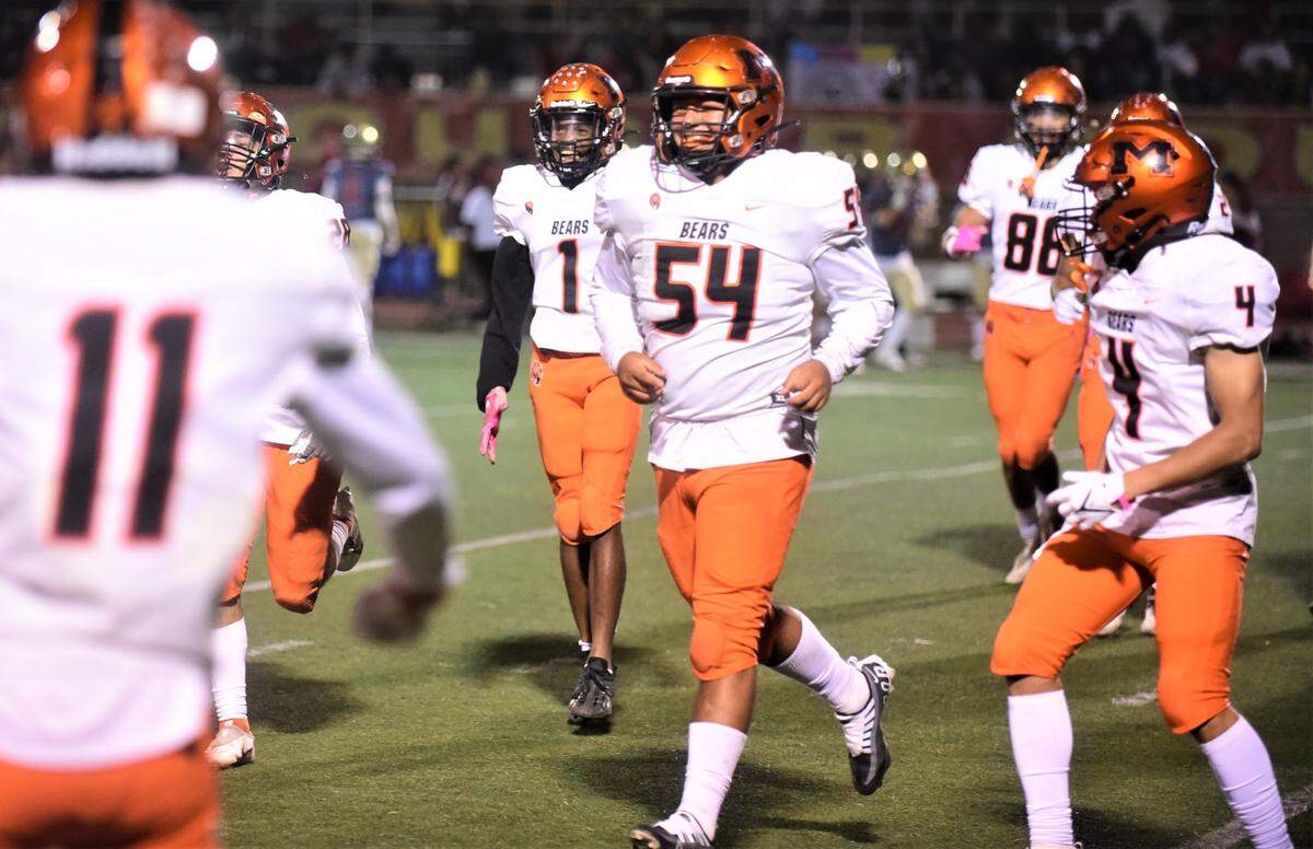 Merced High linebacker Bryant Austin (54) is congratulated by his teammates after intercepting a pass against Golden Valley on Friday, Oct. 28, 2022 at Veterans Stadium in Merced, Calif.