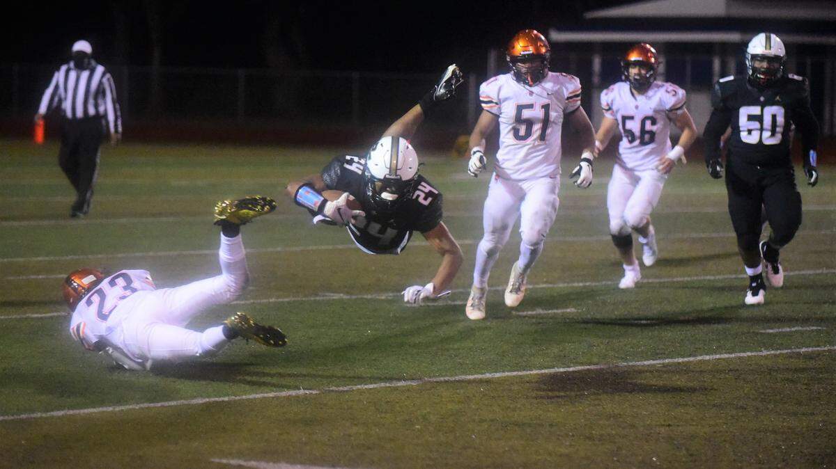 Buhach Colony sophomore running back Jaxson Percoats is upended by Merced defender Julian Morales on Friday, March 19, 2021 at Dave Honey Stadium in Atwater, Calif.