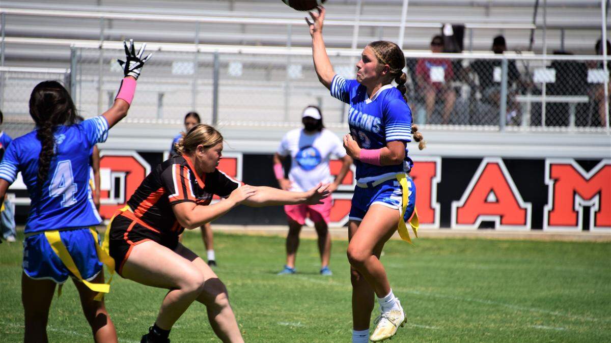 Atwater High School sophomore quarterback Madison Hiler leaps to throw a pass as Merced’s Maddison Cabral rushes during a flag football game on Saturday, Aug. 19, 2023 at Merced High School in Merced, Calif.
