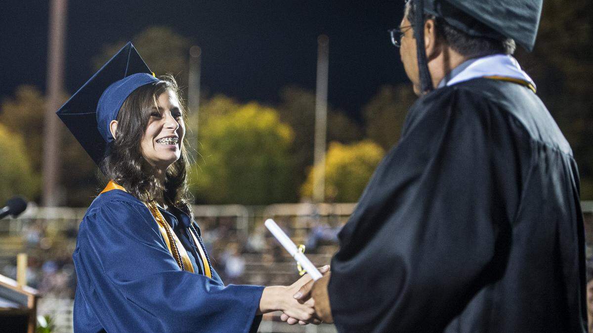 Merced College graduate Cassandra Diaz, 21, of Los Banos, accepts her degree during the Merced College graduation ceremony at Stadium ‘76/Don Odishoo Field on the campus of Merced College in Merced, Calif., Friday, May 27, 2016. 